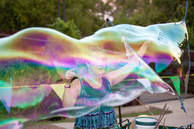 Concert attendee Sunita Bubblady Stone creates bubbles for others to enjoy, Thursday, August 12, 2021, at San Marcos Plaza Park.