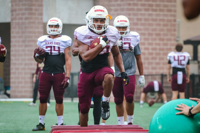 Texas State senior running back Robert Brown Jr. (23) jumps over obstacles while he carries a football during spring practice, Tuesday, March 30, 2021, at Bobcat Stadium.