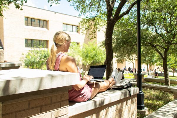 Texas State applied sociology senior April Nance checks Canvas on the first day of classes, Monday, August 23, 2021, on Bobcat Trail.
