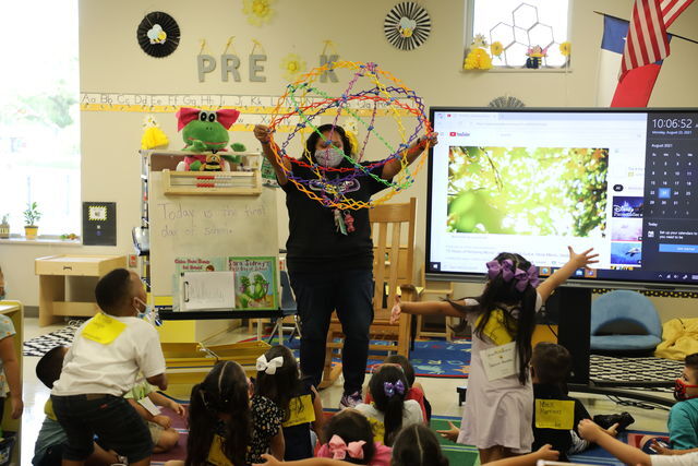 A SMCISD Pre-K teacher engages with students in classroom while wearing masks Monday, August 23, 2021 on SMCISD campus