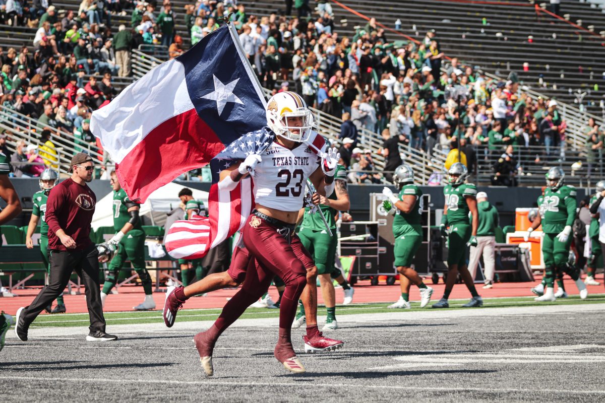 Texas+State+junior+safety+Peyton+Tuggle+%2823%29+carries+the+American+flag+as+the+team+enters+the+field+before+the+game+against+Eastern+Michigan%2C+Saturday%2C+Sept.+25%2C+2021%2C+at+Rynearson+Stadium.+The+Bobcats+lost+59-21.