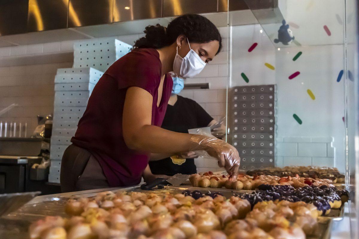 A Mochinut employee helps select a mochi donut for a customer, Thursday, Sept. 9, 2021, in San Marcos, Texas.
