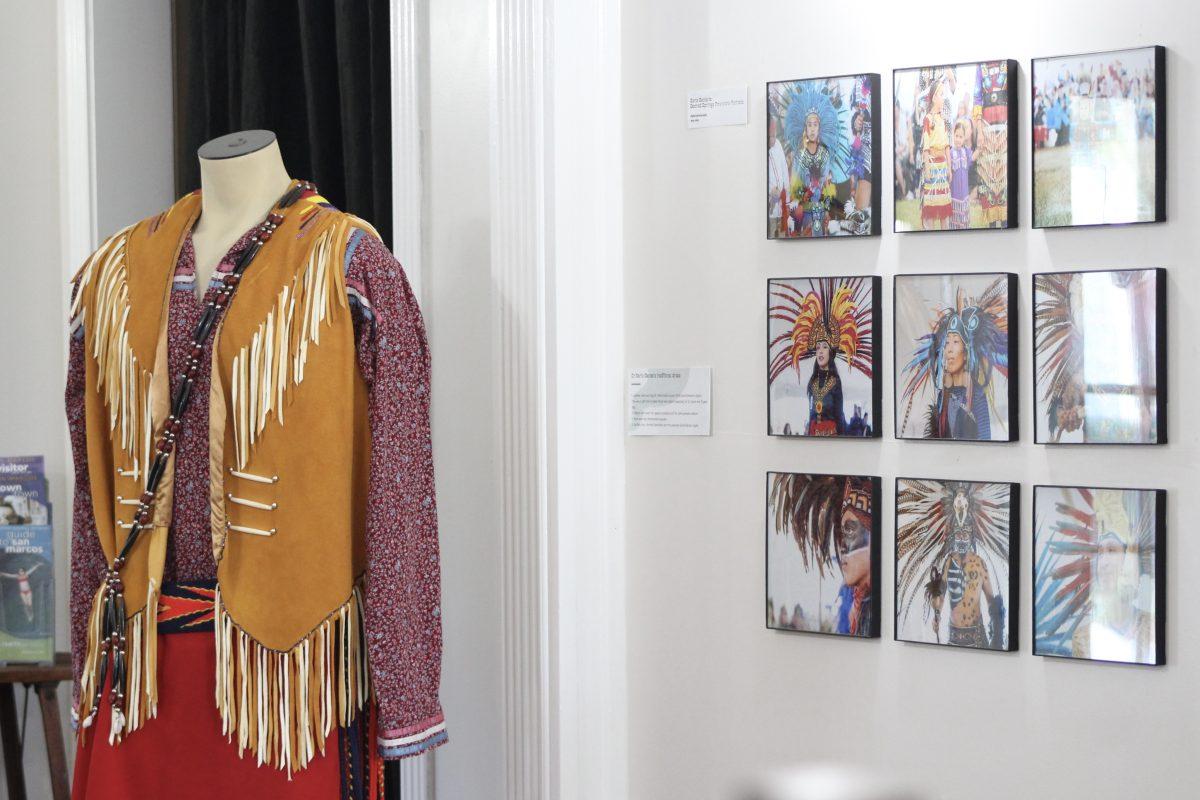 Dr. Mario Garza’s traditional dress along with Rene Renteria’s Sacred Springs Powwow portraits are displayed as part of the Napokō (Our Journey) exhibit, Saturday, Oct. 16, 2021, at the Price Center. The Indigenous Cultures Institute (ICI) of San Marcos created the exhibit to last from Oct. 4 to Nov. 27, and it shares the story of the Indigenous community in San Marcos.