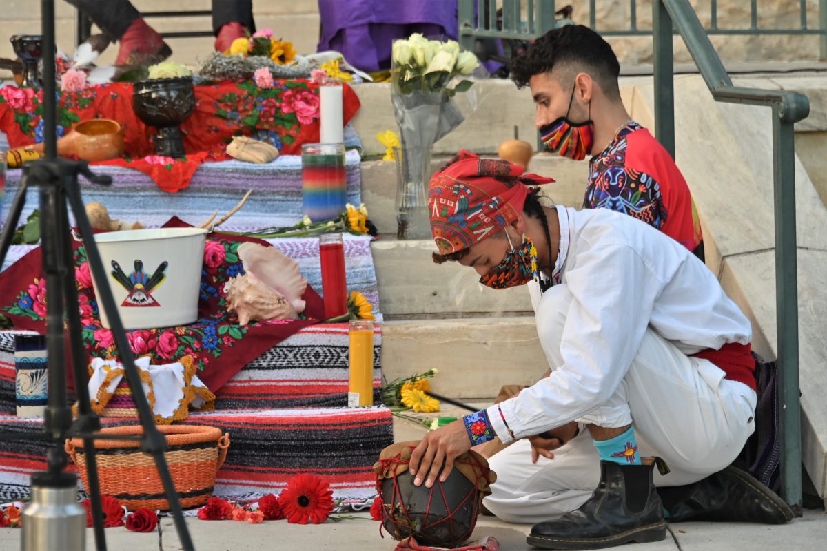 Indigenous Cultures Institute Performances Program Coordinator Mario Alberto Ramirez (front) and Social Media & Online Donations Coordinator José Gomez III perform a prayer song, Monday, Oct. 11, 2021, at the Hays County Historic Courthouse.