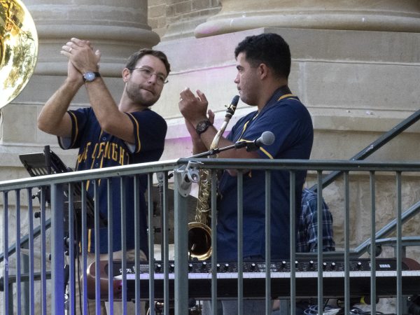 Keaton Ainsworth (left) and Roberto Aponte of the Time of Night Band clap a rhythm for the crowd, Thursday, Oct. 7, 2021, during the Music on the Square concert series outside the Hays County Historic Courthouse in San Marcos.