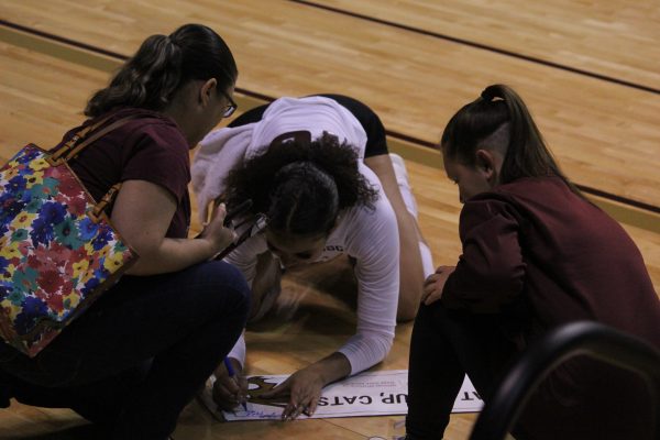 Texas State senior outside hitter Janell Fitzgerald (16) signs fans' posters after the win against Arkansas State, Sunday, Nov. 7, 2021, at Strahan Arena. The Bobcats won 3-1. 