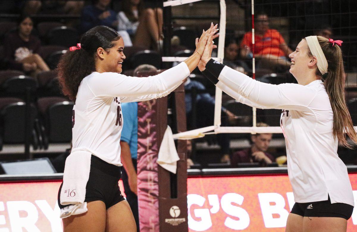Texas State senior hitter Janell Fitzgerald (16) and setter Emily DeWalt (17) high five after the team scores a point over UTA, Thursday, Oct. 7, 2021, at Strahan Arena. The Bobcats won 3-0.