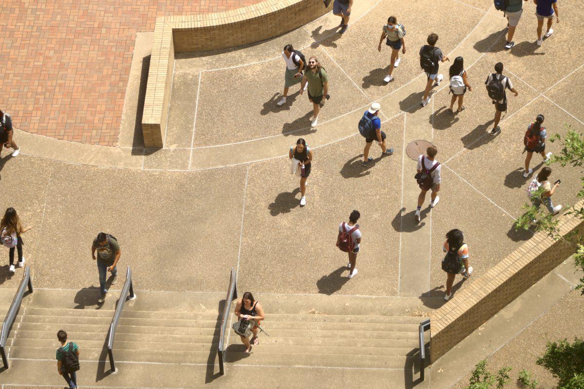 Students head up and down the bottom stairs of Alkek Library, Monday, August 23, 2021, at Texas State.