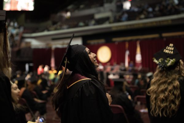 Texas State graduates look to friends and family while waiting to walk the stage, Saturday, Dec. 11, 2021, at Strahan Arena.