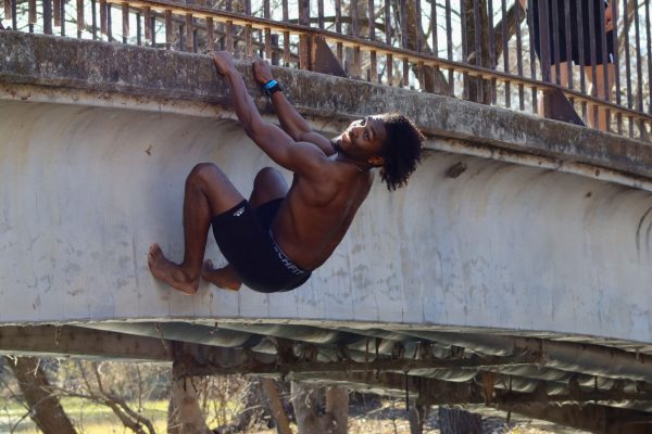 Texas State nutrition and foods junior Jackson Avery climbs across a bridge, Thursday, Feb. 10, 2022, at Sewell Park.