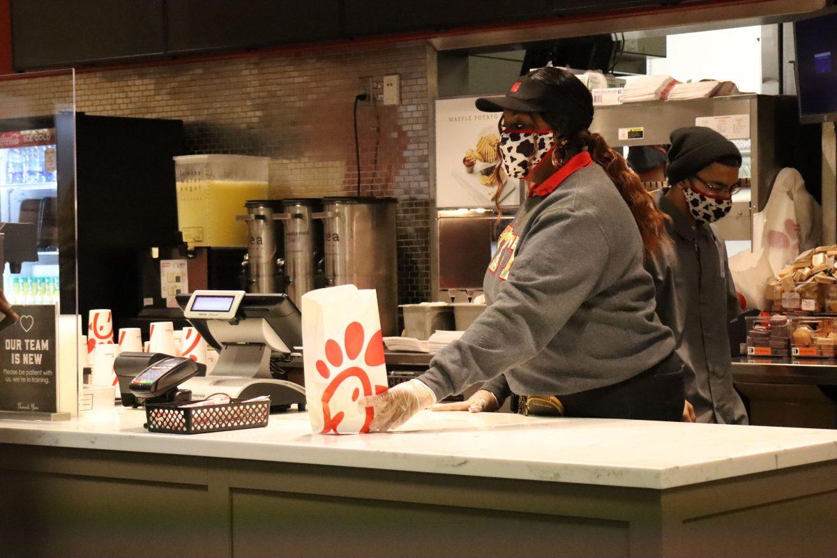 Texas State health science senior Niah Porcher places a customer’s bag of food on the counter, Monday, Feb. 7, 2022, at the LBJSC Chick-fil-A.