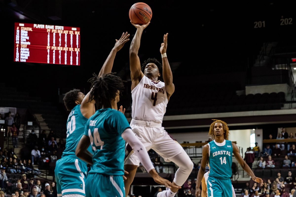 Texas State senior guard Shelby Adams (4) jumps over Chanticleer defenders for a shot into the basket during a game against Coastal Carolina, Sat. Feb 5, 2022, at Strahan Arena. The Bobcats won 69-64.
