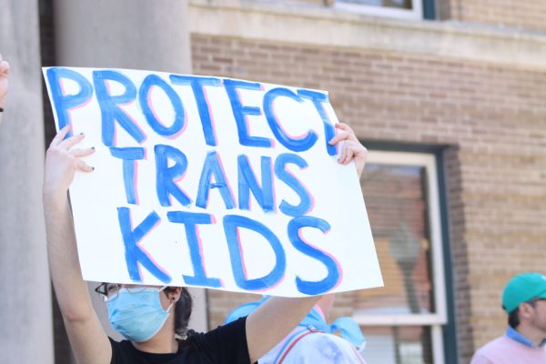 A protestor holds a sign during the March for Trans Youth, Wednesday, March 2, 2022, at the Hays County Historic Courthouse. The march was organized in response to Gov. Greg Abbott’s recent order directing state officials to handle gender-affirming treatment to minors as child abuse.