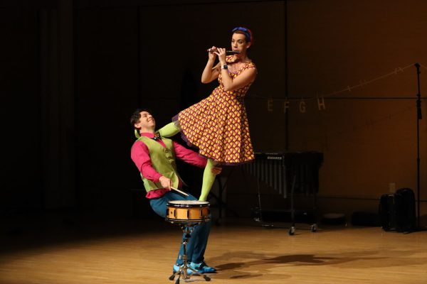 Greg Jukes plays the snare drum while holding up Hilary Abigana as she plays the flute, Sunday, Feb. 27, 2022, at the Performing Arts Center’s Recital Hall.