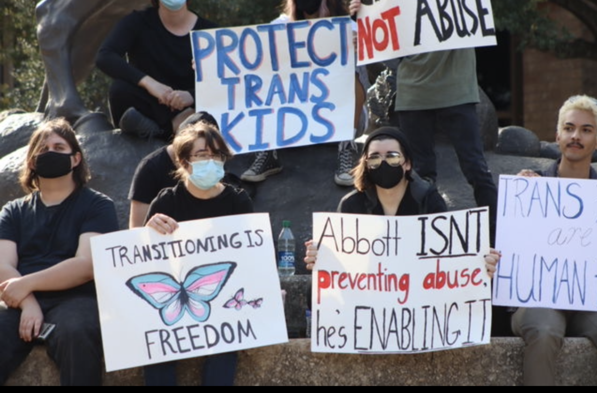 Protestors sit and hold signs at the Stallions during the March for Trans Youth, Wednesday, March 2, 2022, at Texas State. The march was organized in response to Gov. Greg Abbott’s recent order directing state officials to handle gender-affirming treatment to minors as child abuse.