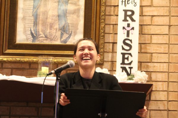 Texas State health sciences junior Isabelle Donnelly shares a smile during her poem at Open Mic Night, Friday, April 22, 2022, at Our Lady of Wisdom University Parish.