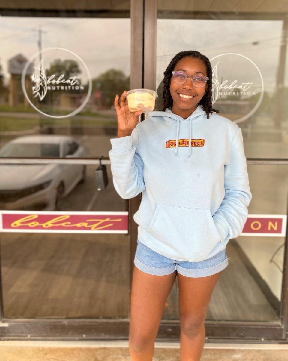 Autumn Williams holds up her banana pudding in front of Bobcat Nutrition.