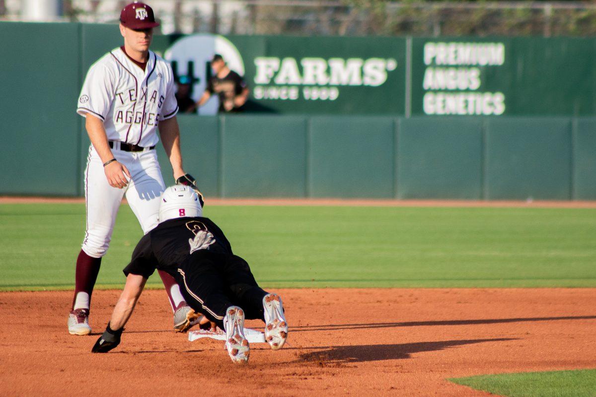 Texas State senior infielder Dalton Shuffield (8) slides back into second base after a pickoff attempt during a game against Texas A&M, Tuesday, April 5, 2022, at Blue Bell Park. The Bobcats lost to the Aggies 4-8.