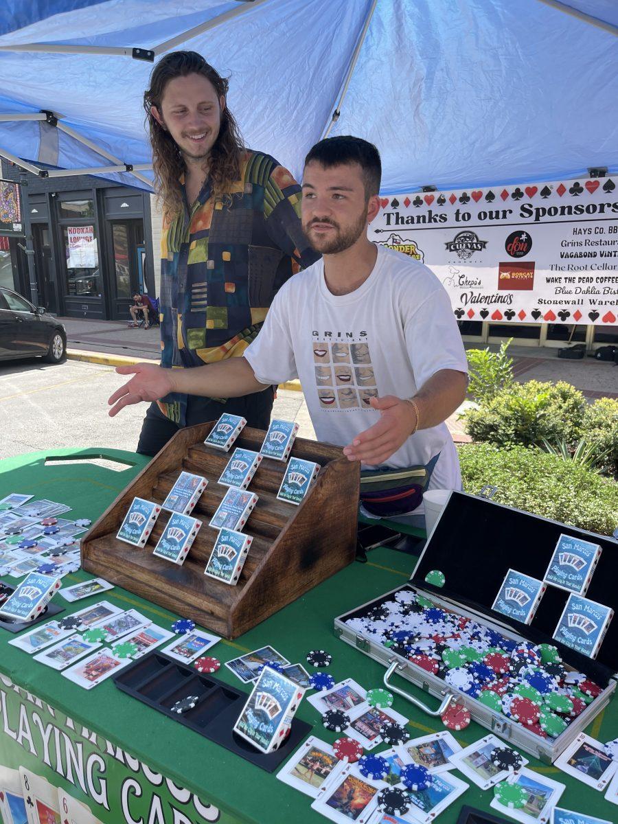 Creighton Coyne (left) and Luke Merchant sell their San Marcos-themed playing cards at the San Marcos Farmers Market, Saturday, Aug. 27 2022, on The Square.