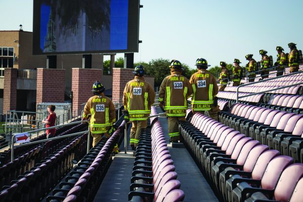 Buda Firefighters pause and look towards the screen displaying footage of the Twin Towers on 9/11 during the 2nd annual Hays County 9/11 Memorial Stair Climb, Sunday, Sept. 11, 2022, at Bobcat Stadium. 