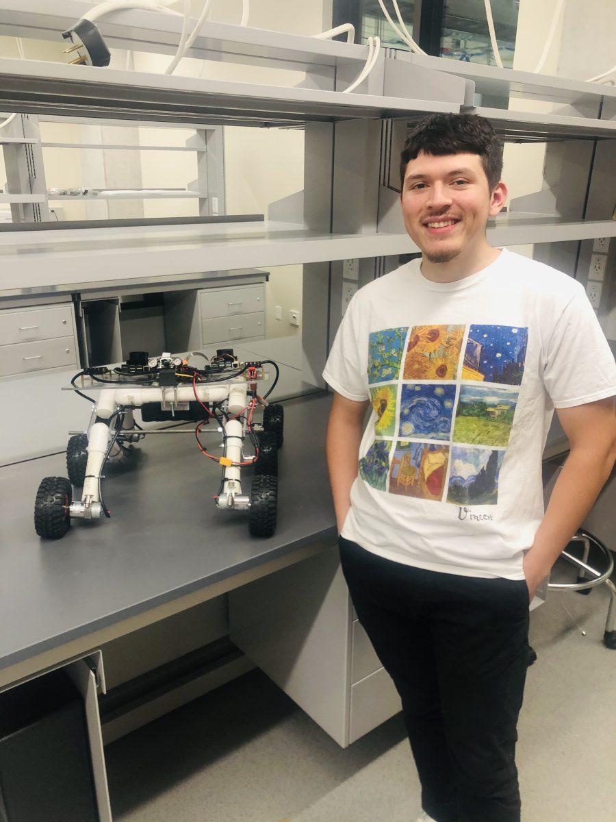 Texas State electrical engineering senior Oscar Resindez smiles with the Dell-funded robot he is working on, Thursday, Sept. 15, 2022 at the Ingram School of Engineering. The robot will be working with the San Marcos firefighters in future semesters.