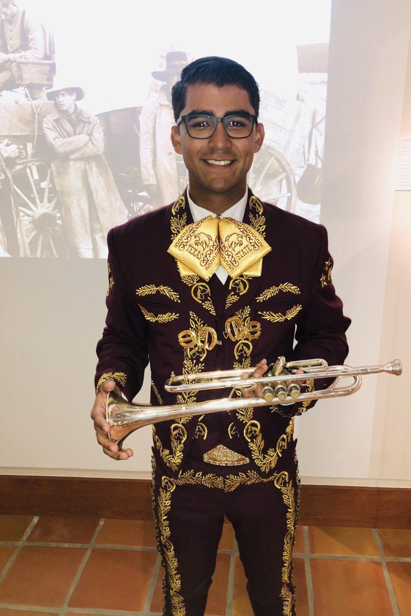 Texas State music junior Jonathan Martinez smiles in his Mariachi Nuevo Generación uniform at The Wittliff Collections in Alkek Library.