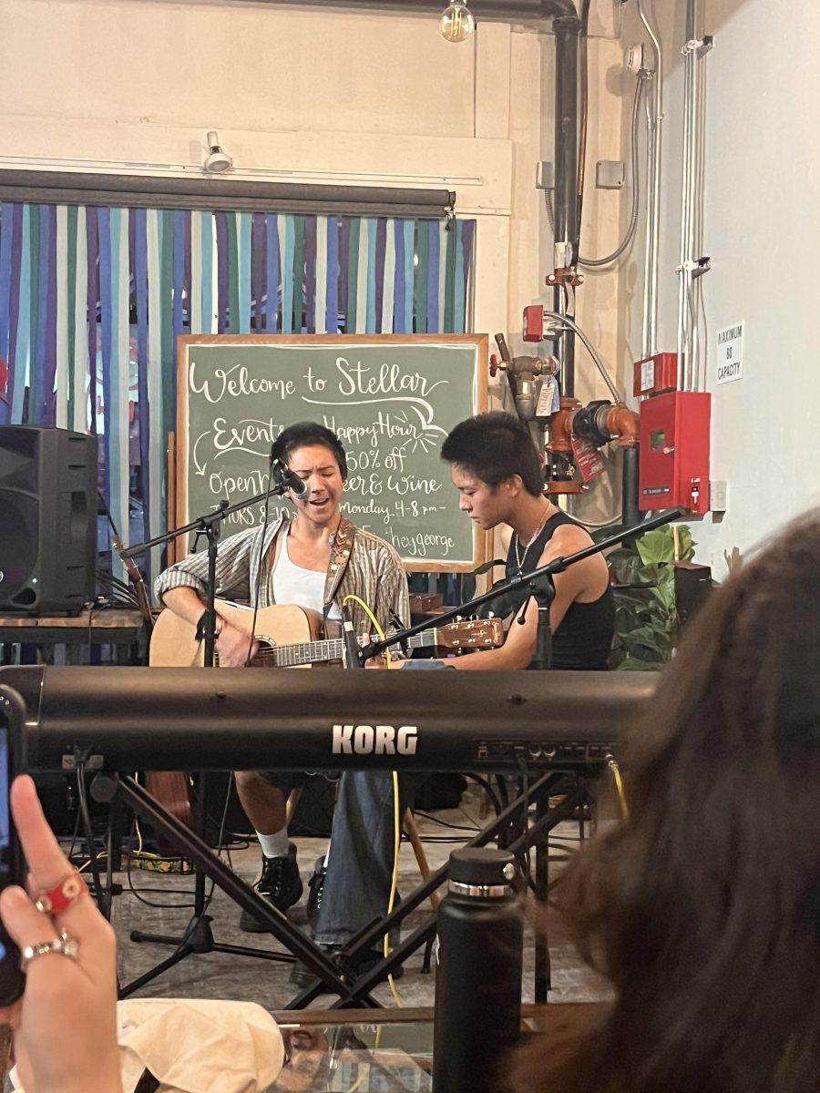 Texas State exploratory freshman Zen Fernandez (left) performs at open mic night with sight reading assistance from his brother, Zain Fernandez, Thursday, Sept. 22, 2022, at Stellar Coffee Co. 