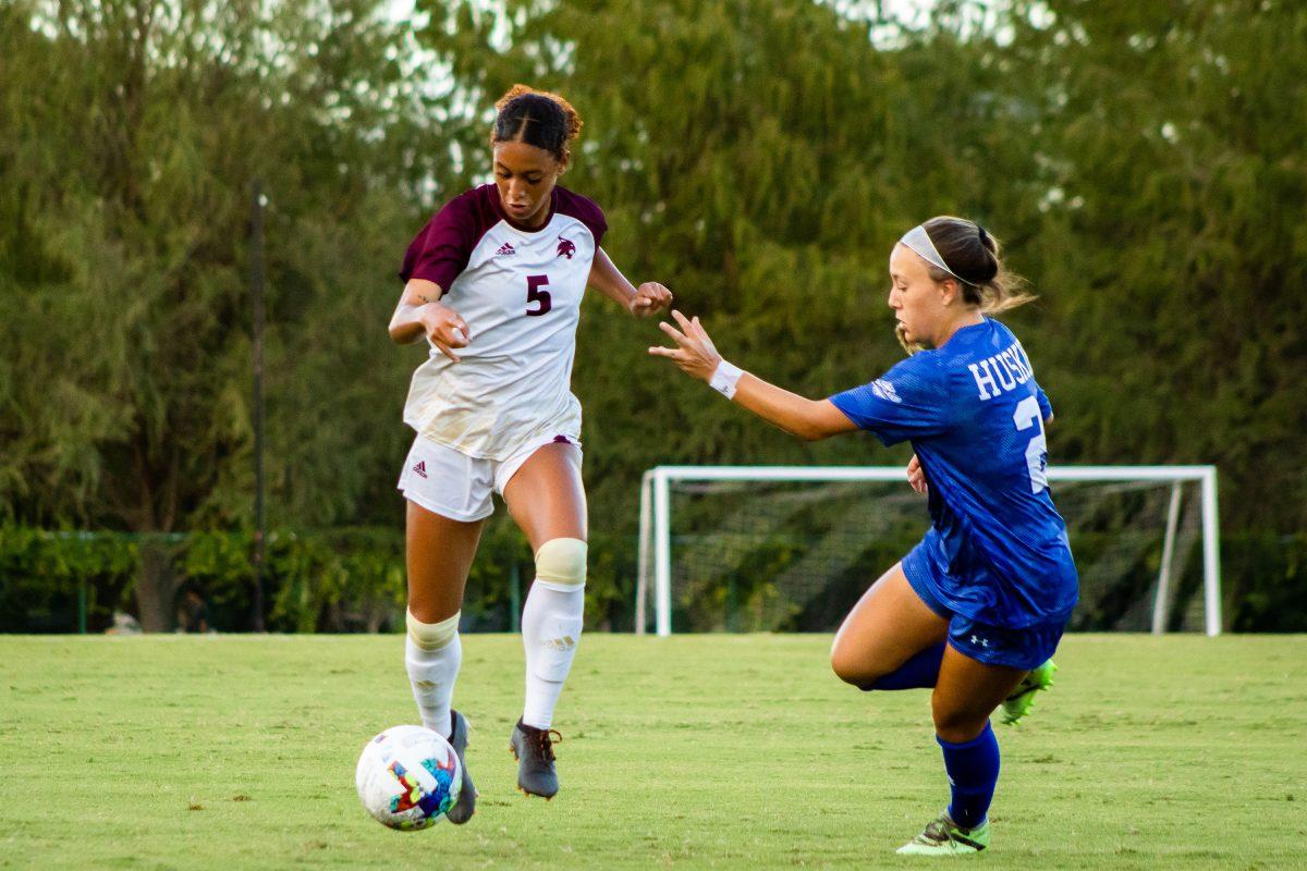 Texas State sophomore midfielder Madi Goss (5) dribbles the ball away from Huskie defenders during a game against Houston Baptist, Sunday, August 28, 2022, at Bobcat Soccer Complex. The Bobcats won 2-1.