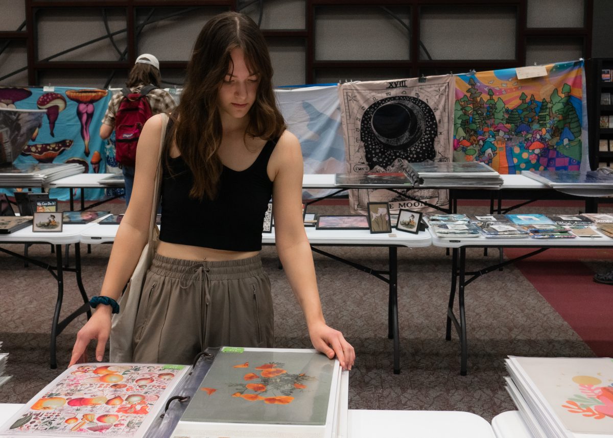 Texas State nursing sophomore Corra Lavinder flips through a poster book, Tuesday, Jan. 17, 2023, in the LBJ Ballroom. The Student Association for Campus Activities (SACA) hosts a poster sale every semester.