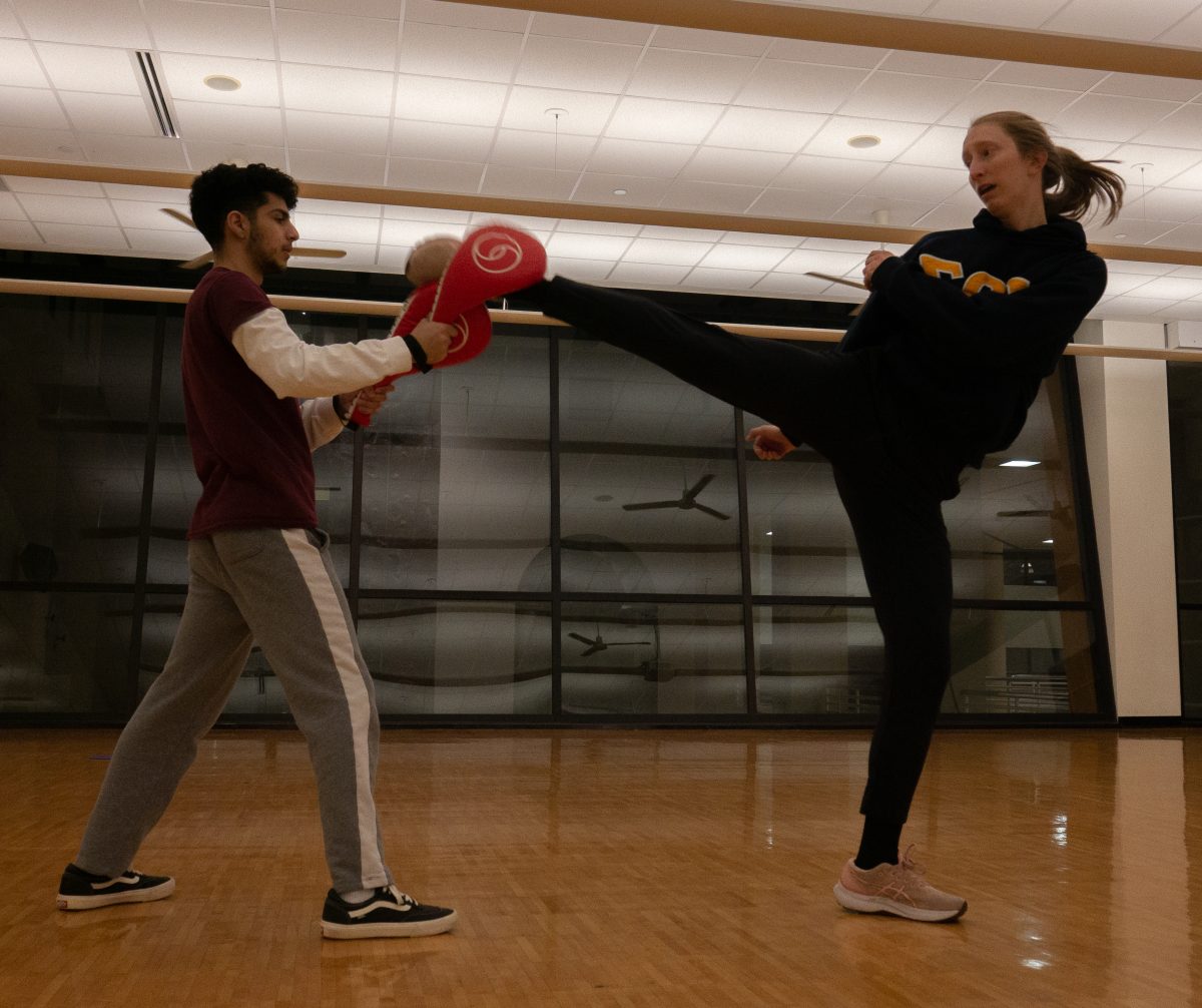 Texas State exercise and sport science sophomore Leo Arellano (left) practices kicking combo drills with anthropology graduate student Anna Huntington, Friday, Feb. 3, 2023, at Texas State Recreational Center.