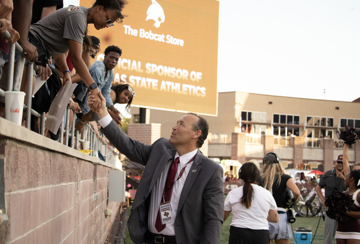 Texas State President Kelly Damphousse greets students on the sidelines at the homecoming football game against Southern Miss, Saturday, Oct. 22, 2022. 