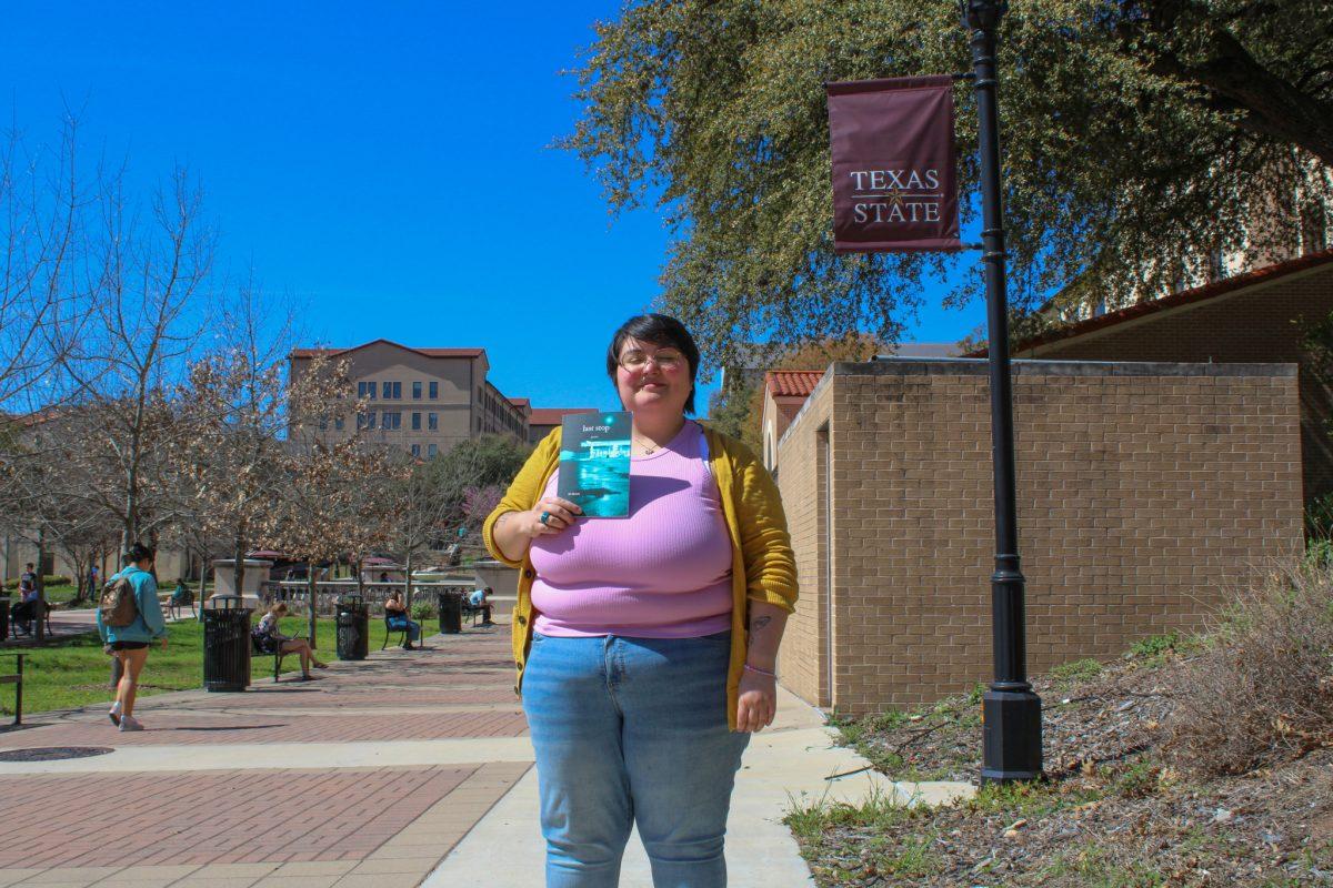 Texas State creative writing graduate student SG Huerta holds their chapbook titled Last Stop, Monday, Feb. 27, 2023, in front of Flowers Hall. The books poems were written during a time when Huerta was dealing with the grief of losing their father to suicide.