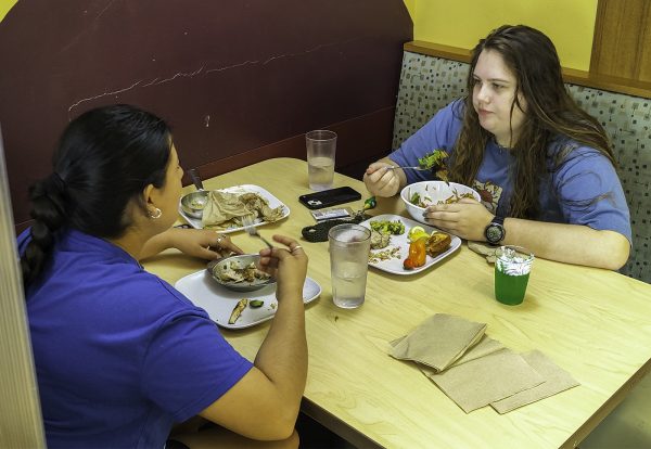 Elementary education freshman Ashley Morin (left) and biology freshman Kathryn Elizabeth Yoas eat food served at the St. Patrick's Day Feast Friday, March 10, 2023, at Commons Dining Hall.