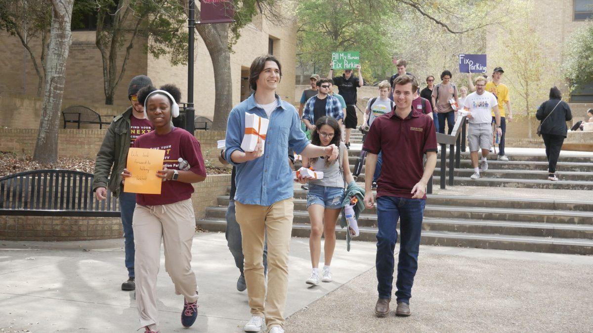 ParkTXST president Catching Valentinis-Dee (center) and political science junior Tennyson Moreno (right) walk side by side leading the rally through the Quad on Wednesday, March 8, 2023.
