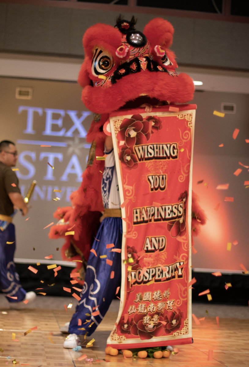 Heavenly Dragon Lion Dance wishes luck upon the audience with banner, Wednesday, April, 12, 2023, at LBJSC Ballroom.