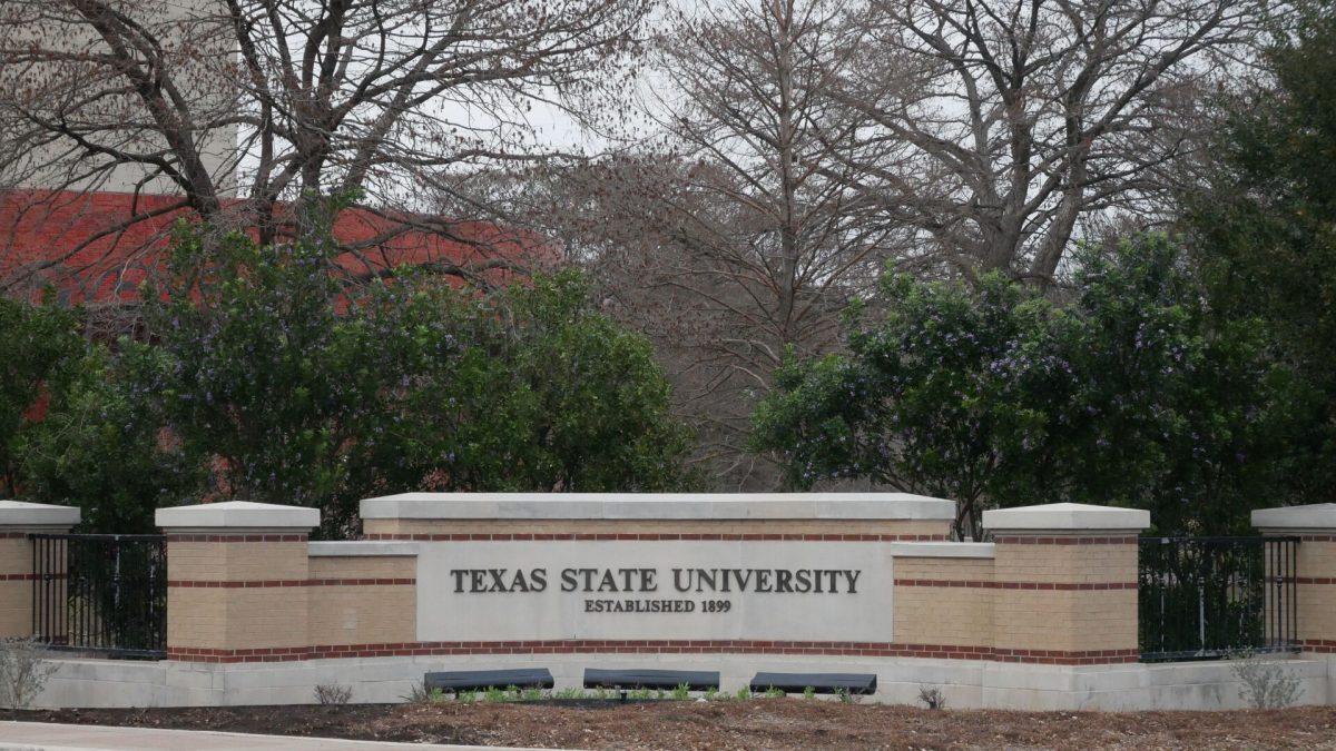A photo of the Texas State University sign in front of the Performing Arts Center.