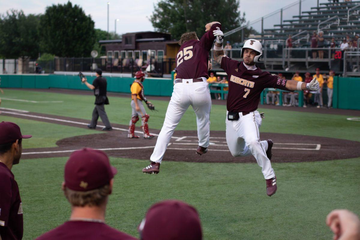 Texas State right handed pitcher junior Levi Wells (left, 25) and sophomore infielder Daylan Pena (7) celebrate the homerun scored against Louisiana-Monroe University, May 18, 2023, at Bobcat Ballpark. Texas State won 6-5.