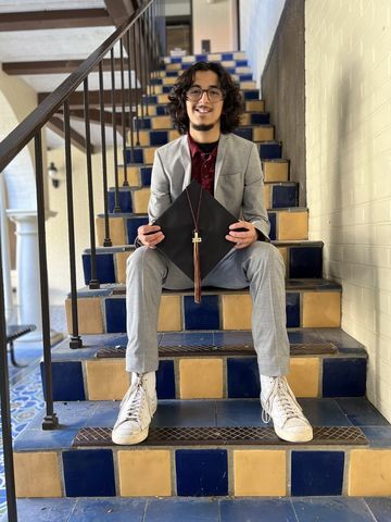 Xavier Zamarron poses for a photo with his graduation cap, Sunday, April 16, 2023, inside the Taylor-Murphy courtyard.