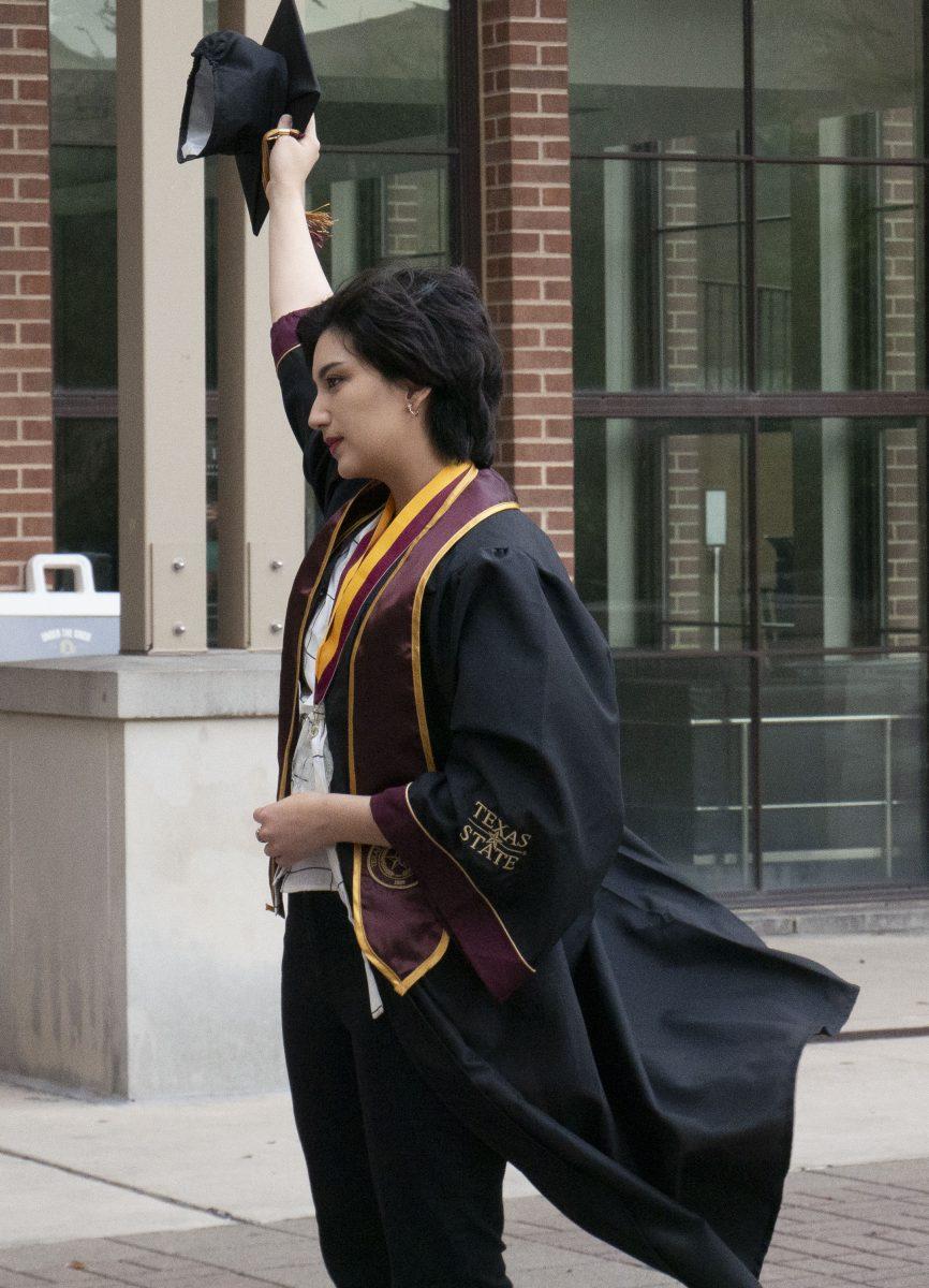 Texas State senior Jules Cabrera poses for graduation photos Sunday, May 7, 2023, near the UAC arch.