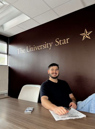 Texas State journalism senior, former news editor, former Editor-in-Chief, current advertising executive Arthur Fairchild poses for an Instagram picture after being deleted to be the Editor-in-Chief for the 2022-2023 school year, Tuesday, May 3, 2022, in the Trinity building conference room. 