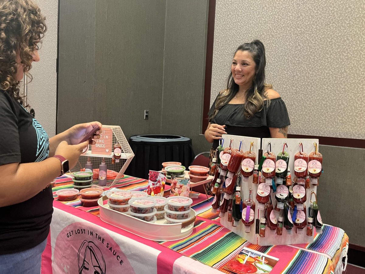 Stephanie Tijerina talks to a customer about her company Besitos Chamoy, Wednesday, Sept. 13, 2023, at HSI Community Day hosted in the LBJ Student Center. 