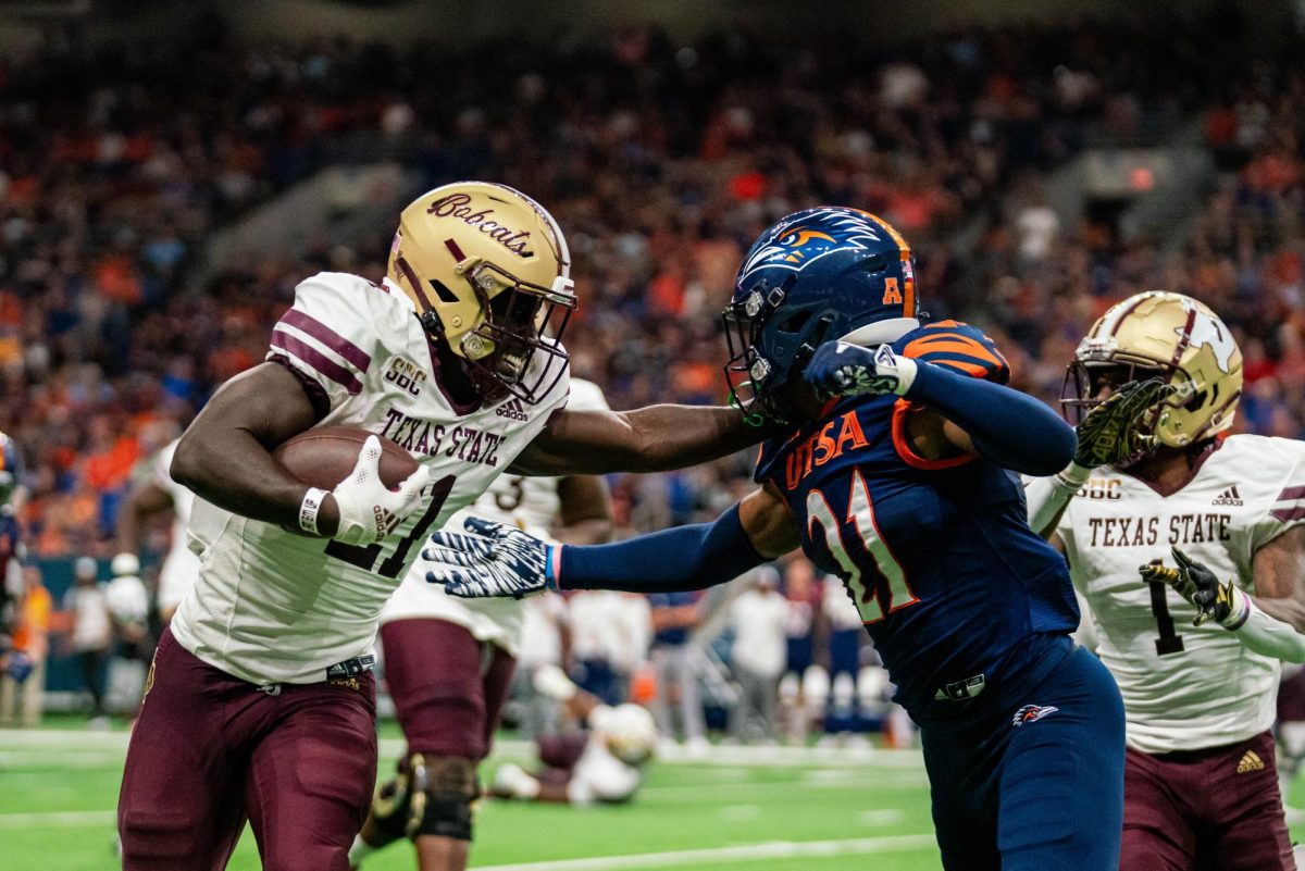 Texas State sophomore running back Ismail Mahdi (21) stiff arms a UTSA defender, Saturday, Sept. 9, 2023, at the Alamodome. 