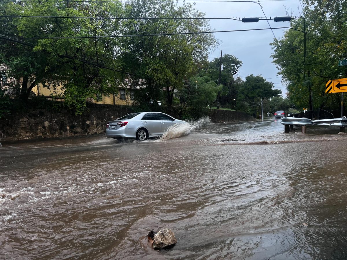 A car drives through a flooded street, Thursday, Oct. 26, 2023, near Old Ranch Road 12 and Blanco Street in San Marcos.