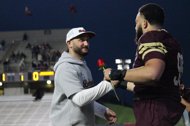Texas State Head G.J. Kinne hands a player a rose during the senior pre-game ceremony, Saturday, Nov. 25, 2023, at Bobcat Stadium.