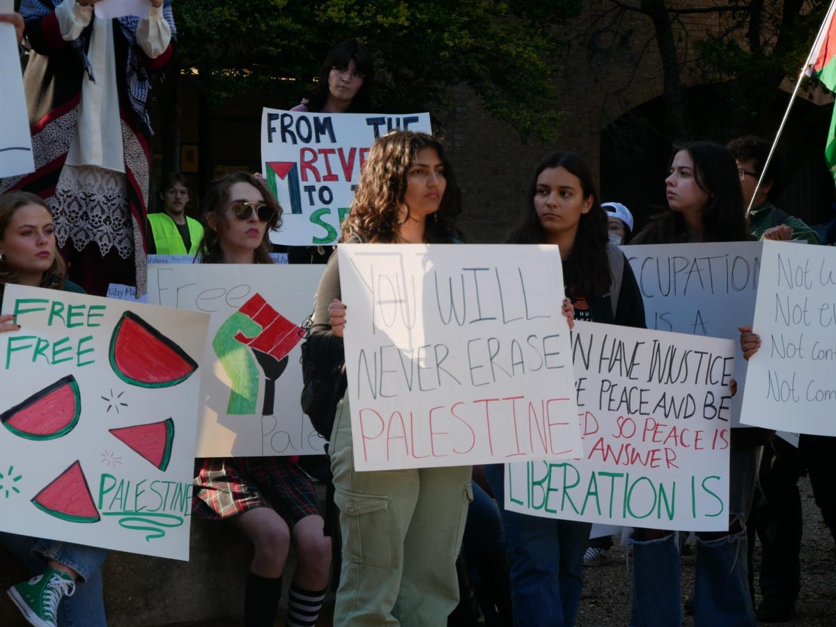 A member of Palestine Solidarity SMTX holds a sign in support of Palestine, Tuesday, Nov. 28, 2023, at The Stallions.