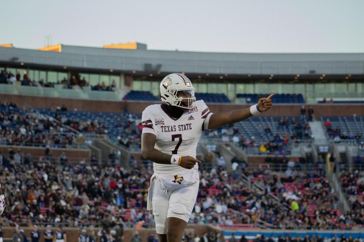 Texas State redshirt sophomore quarterback T.J. Finley (7) discusses the play call with senior running back Jahmyl Jeter, during the SERVPRO First Responder Bowl game versus Rice, Tuesday, Dec. 26, 2023, at Gerald J. Ford Stadium.