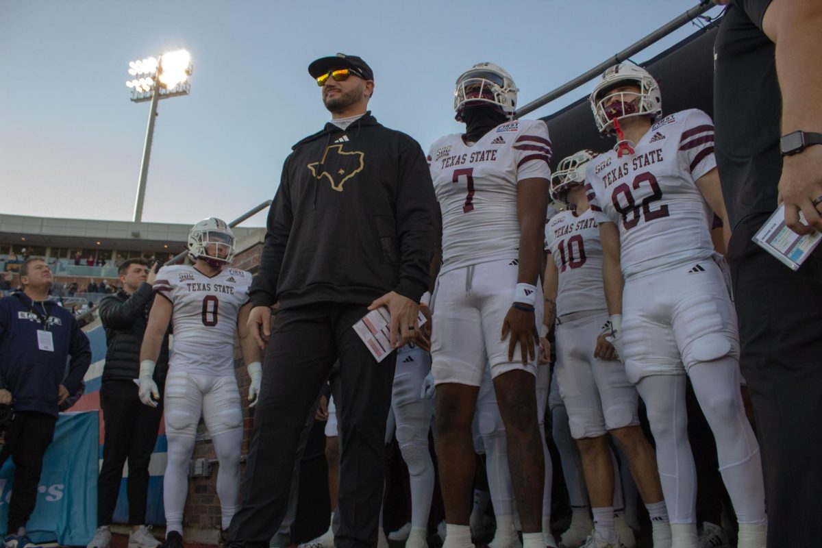 Texas State head coach G.J. Kinne awaits the field alongside sophomore quarterback T.J. Finley prior to the SERVPRO First Responder Bowl game versus Rice, Tuesday, Dec. 26, 2023, at Gerald J. Ford Stadium in Dallas.