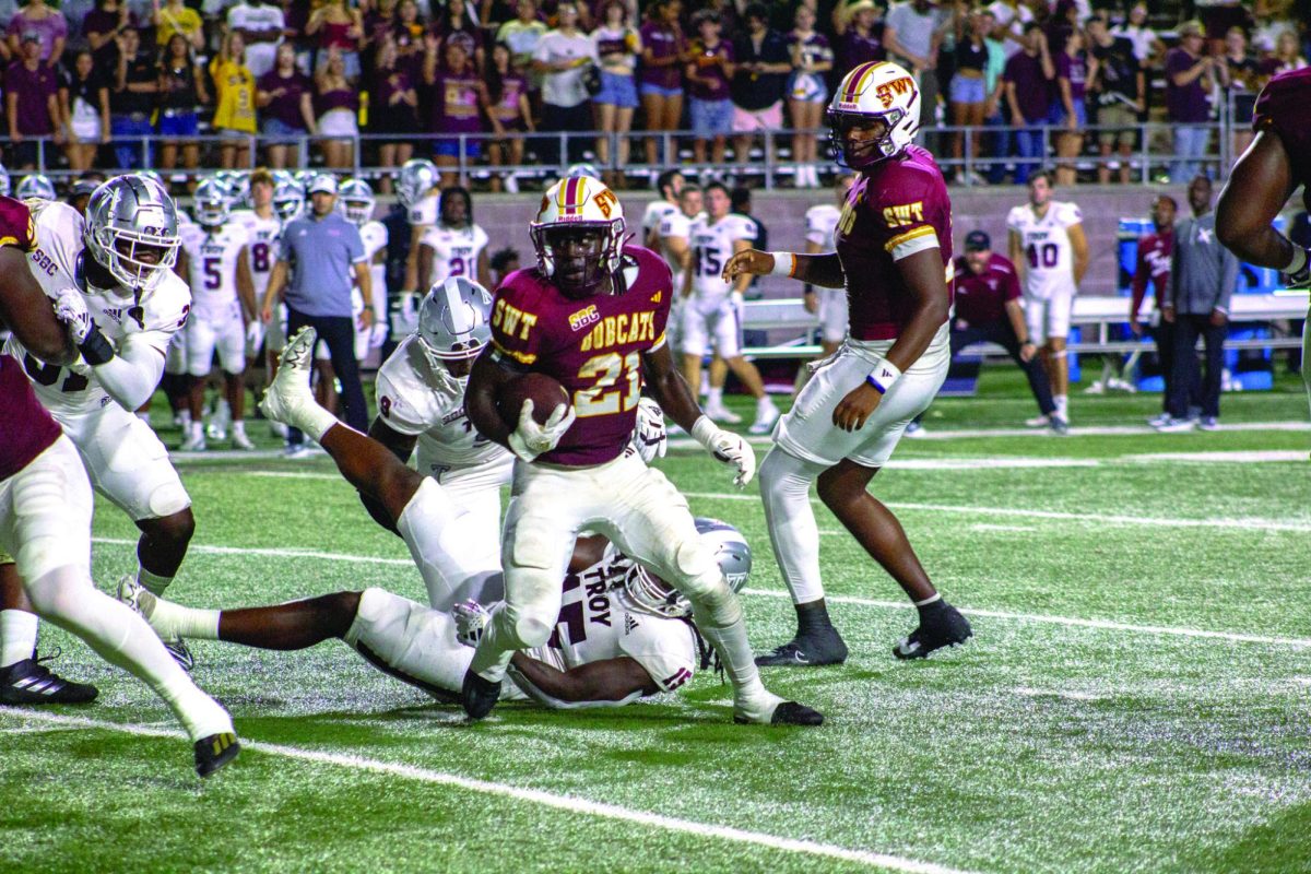 Texas State sophomore running back Ismail Mahdi (21) breaks a tackle for extra yardage versus Troy, Saturday, Oct. 28, 2023, at Bobcat Stadium. 