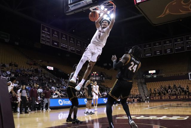 Texas State sophomore forward Davion Sykes (4) hangs on the rim of the basket after a dunk, Wednesday, Feb. 7, 2024, at Strahan Arena. 