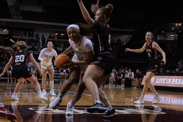 Texas State freshman forward Julia Coleman (12) pushes pass opponent during the game against Denver, Thursday, December 14, 2023, at Strahan Arena.